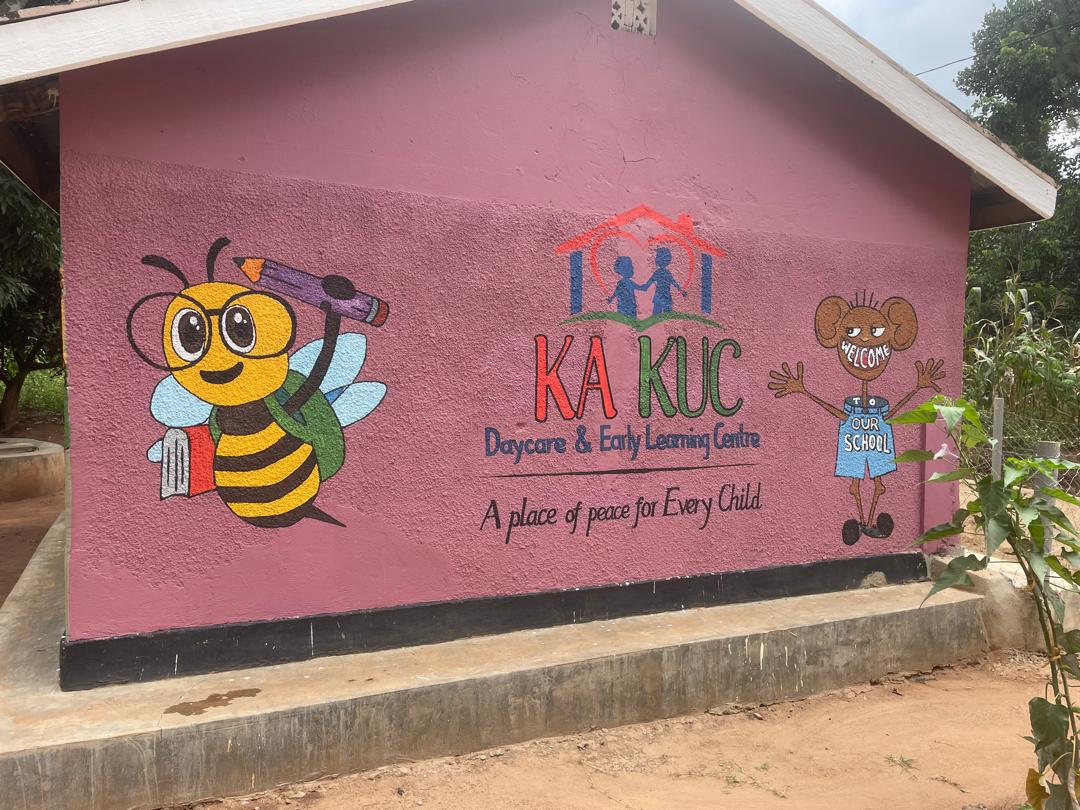 Kakuc Day Care wall with a cheerful bee, welcoming child, and place of peace message